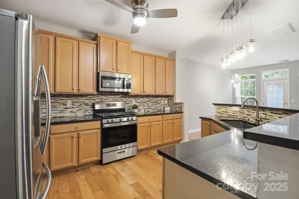 a kitchen with stainless steel appliances granite countertop a stove and a sink