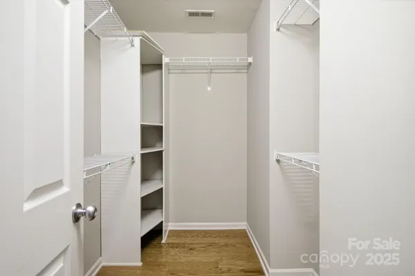 a view of walk in closet with empty racks