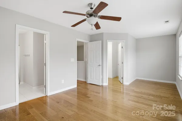 a view of an empty room with window and wooden floor
