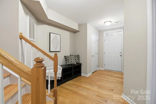 a view of a hallway with wooden floor and staircase