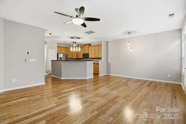 a view of a kitchen with wooden floor and a ceiling fan