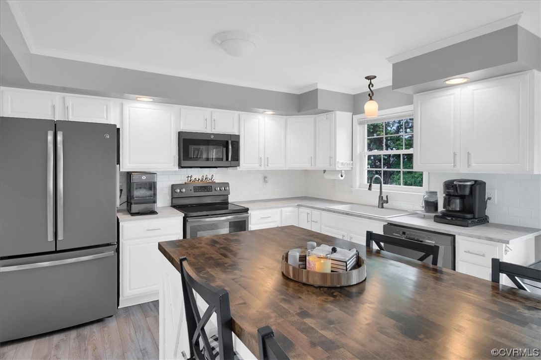 7719 Drexelbrook Road Chesterfield, VA 23832 - Photo 15 of 49 a kitchen with a refrigerator a stove a sink dishwasher a dining table and chairs with wooden floor