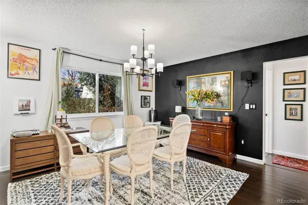 a dining room with furniture a chandelier and wooden floor