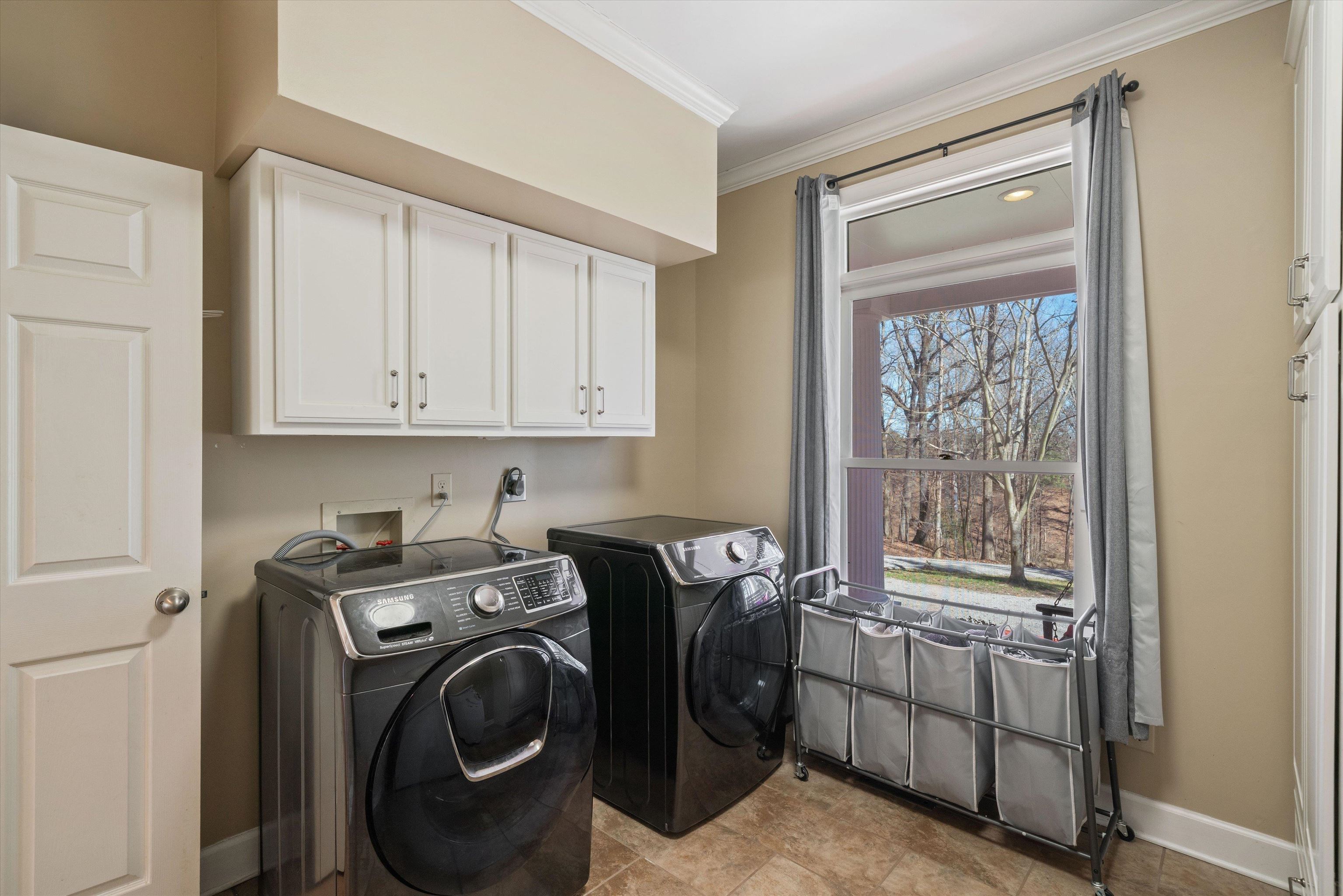 1805 Russell Road Bolivar, TN 38008 - Photo 16 of 39 Clothes washing area featuring cabinet space, washing machine and dryer, ornamental molding, and baseboards