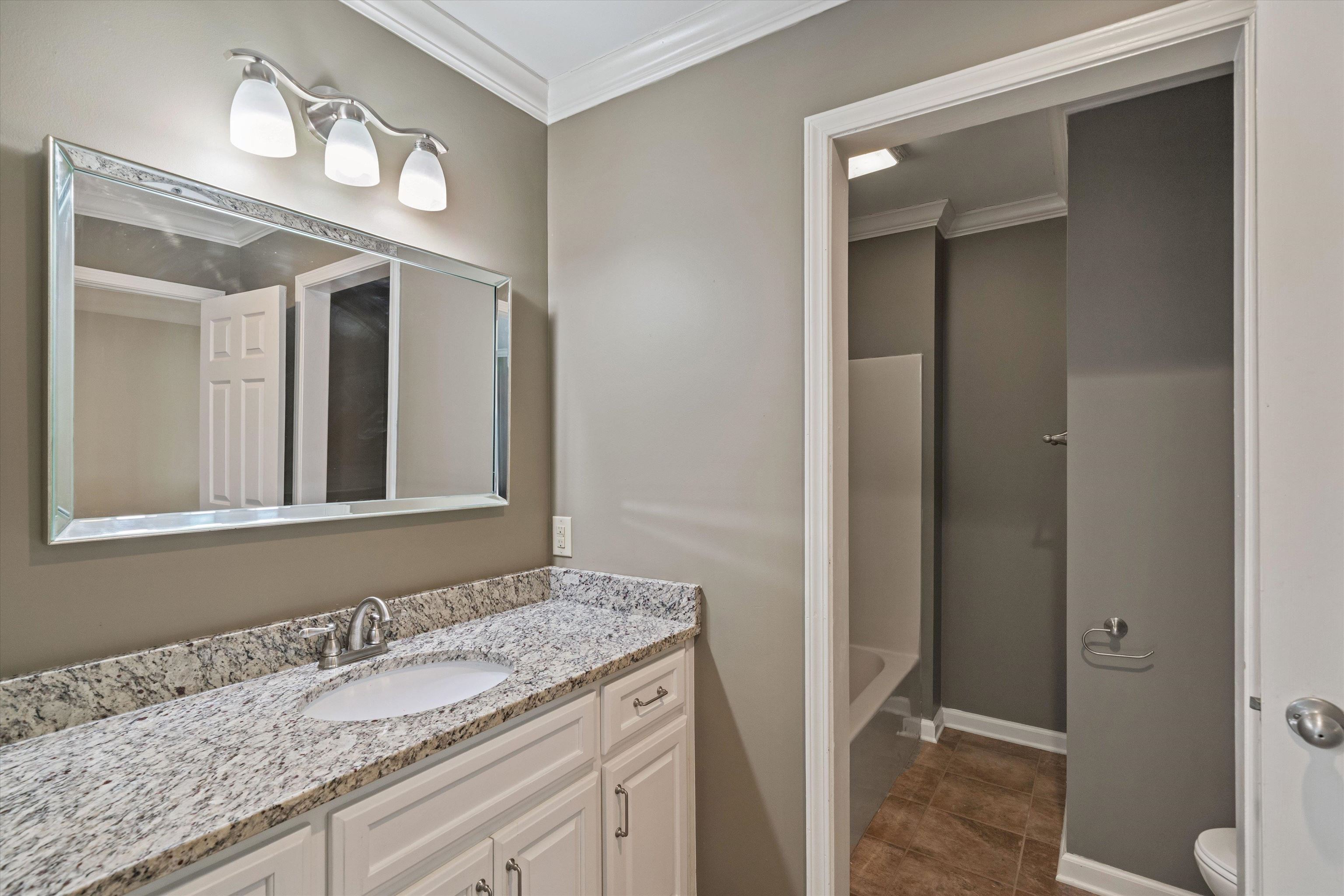 1805 Russell Road Bolivar, TN 38008 - Photo 24 of 39 Full bathroom featuring a washtub, crown molding, toilet, vanity, and tile patterned flooring
