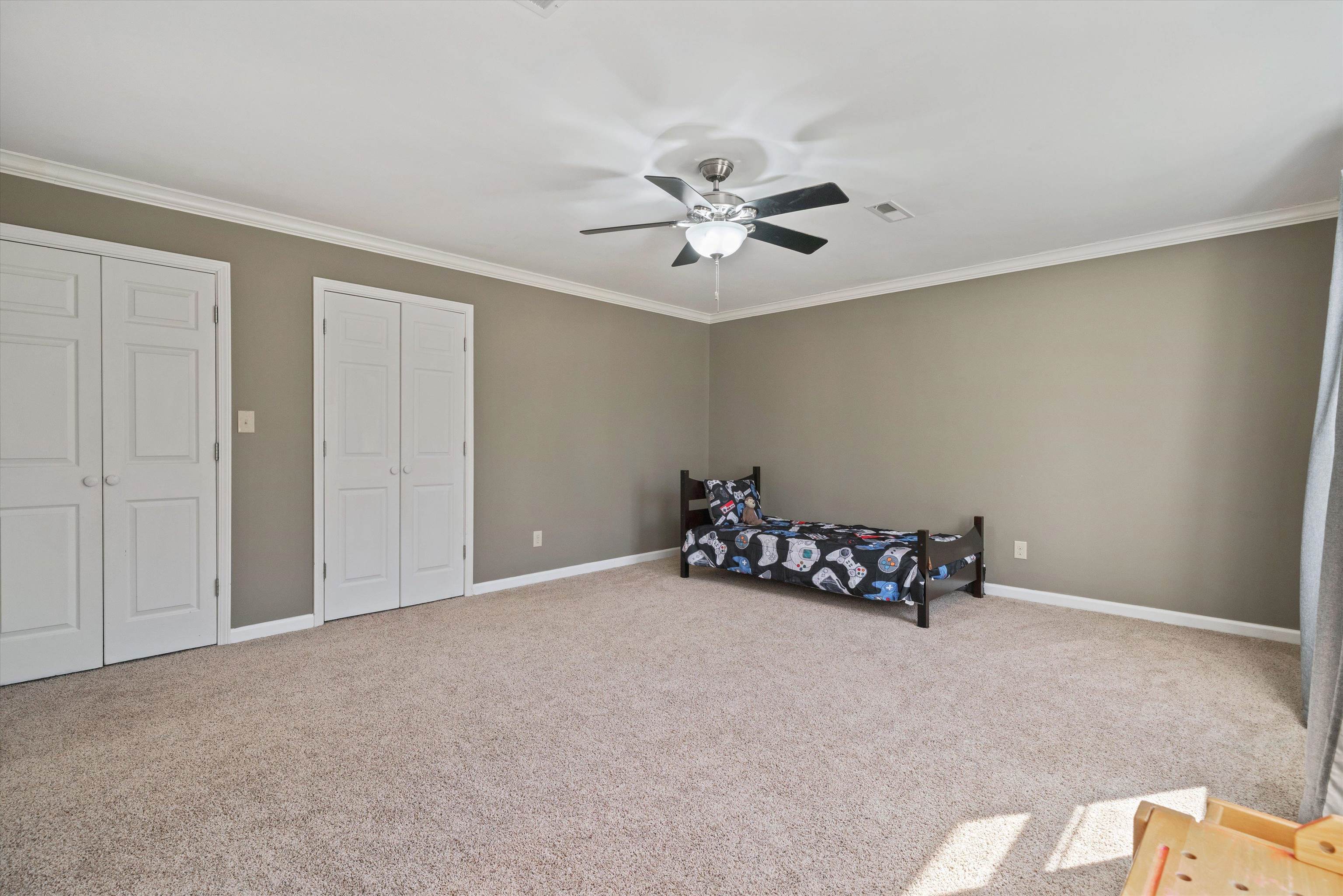 1805 Russell Road Bolivar, TN 38008 - Photo 25 of 39 Carpeted bedroom with visible vents, baseboards, a ceiling fan, crown molding, and two closets