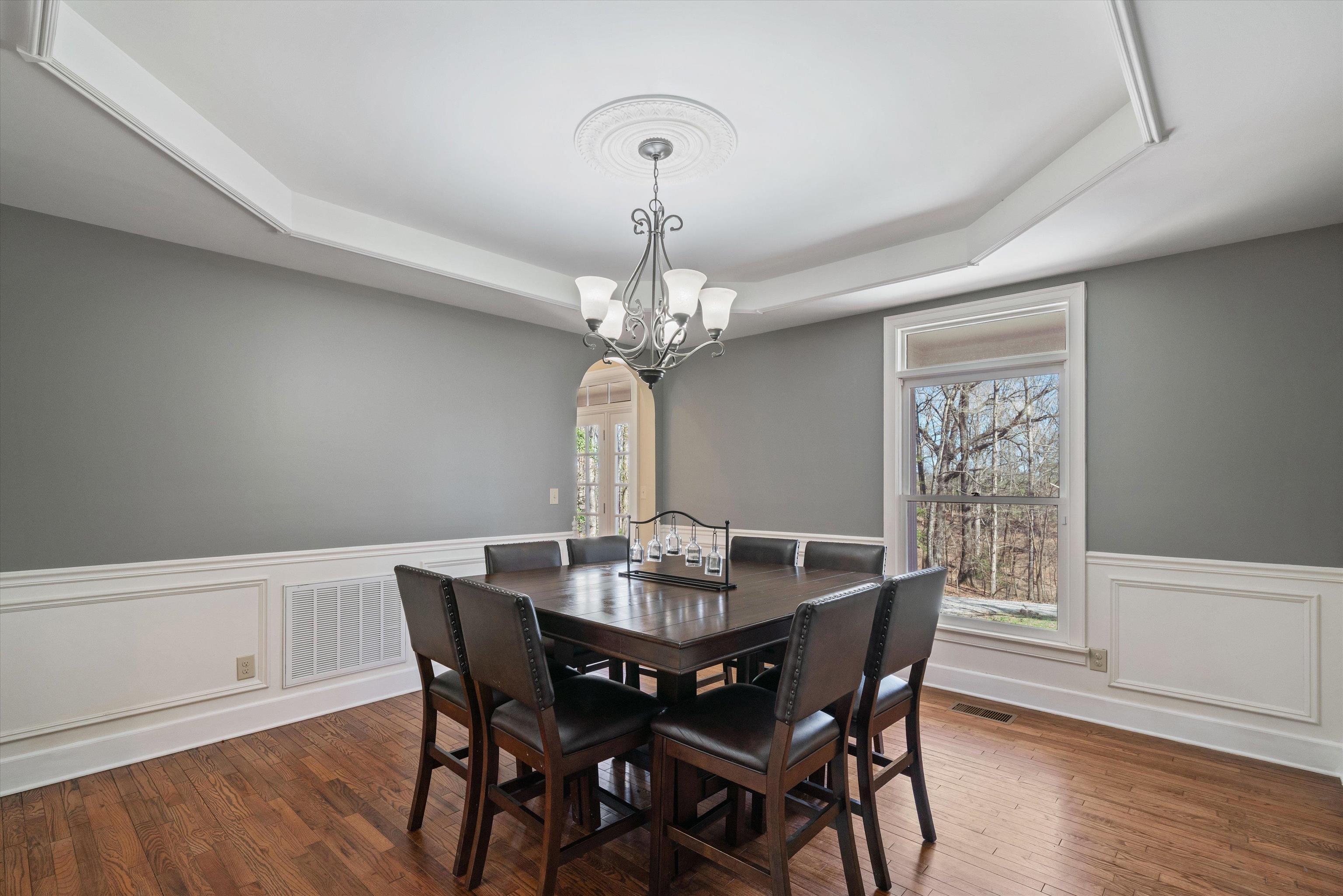 1805 Russell Road Bolivar, TN 38008 - Photo 4 of 39 Dining room featuring arched walkways, visible vents, a raised ceiling, and wood finished floors