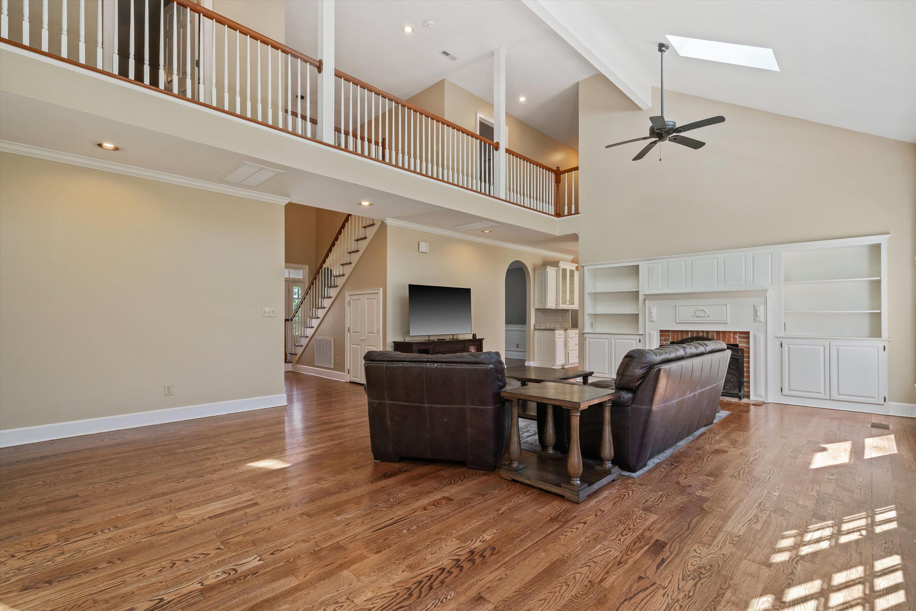 1805 Russell Road Bolivar, TN 38008 - Photo 6 of 39 Living area featuring a fireplace, wood finished floors, baseboards, stairs, and beam ceiling