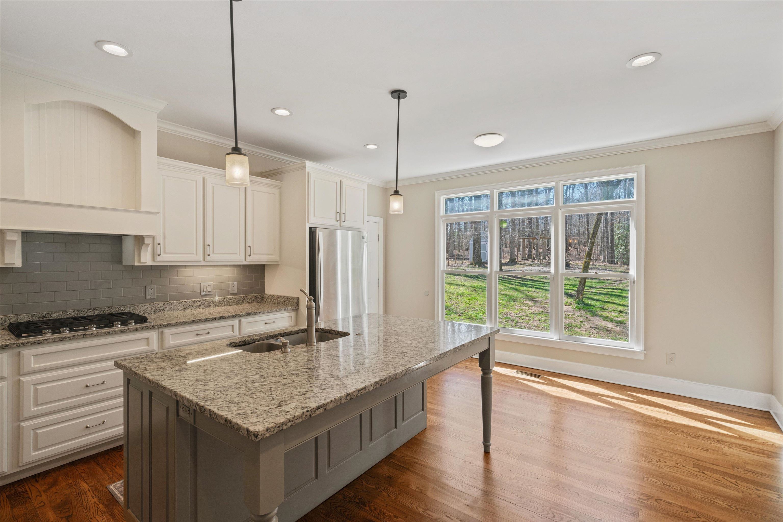 1805 Russell Road Bolivar, TN 38008 - Photo 8 of 39 Kitchen with crown molding, backsplash, appliances with stainless steel finishes, dark wood-type flooring, and a sink