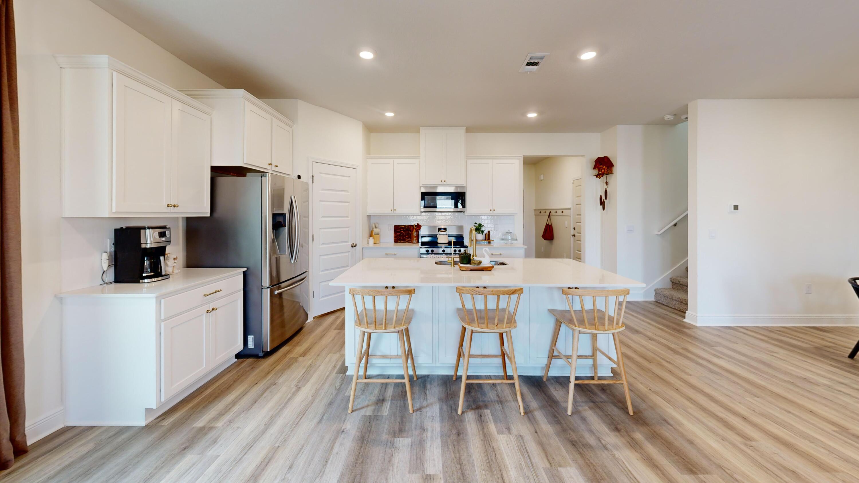 8130 Fir Tree Drive Milton, FL 32583 - Photo 3 of 17 a kitchen with stainless steel appliances a refrigerator a stove a sink dishwasher and a dining table with wooden floor