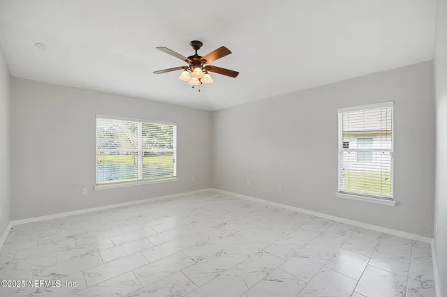 a spacious bedroom with a bed and a plant