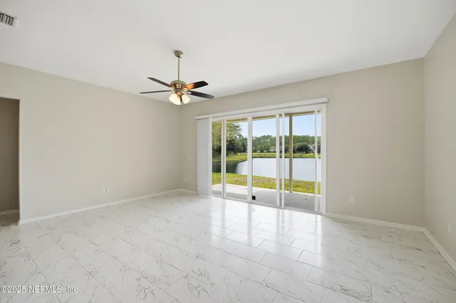 a living room with furniture a flat screen tv and kitchen view