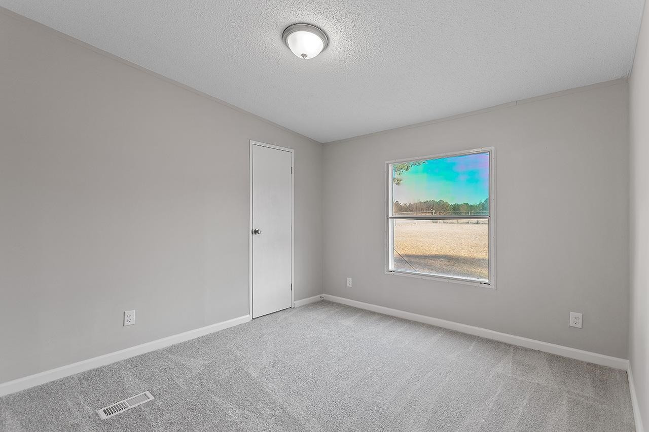 8401 South Creek Road Willow Spring, NC 27592 - Photo 16 of 24 an empty room with windows