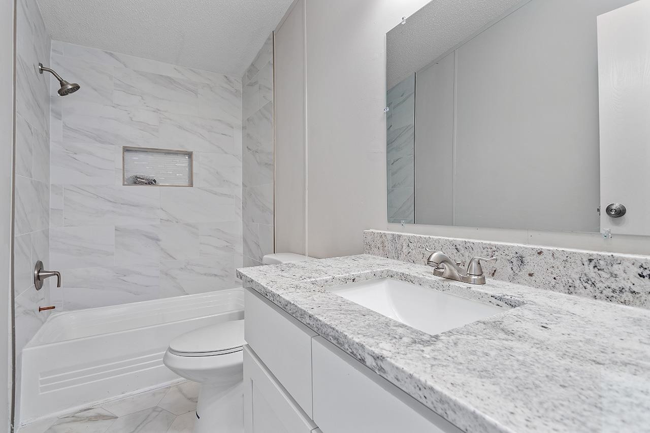 8401 South Creek Road Willow Spring, NC 27592 - Photo 17 of 24 a bathroom with a granite countertop sink a toilet and bathtub