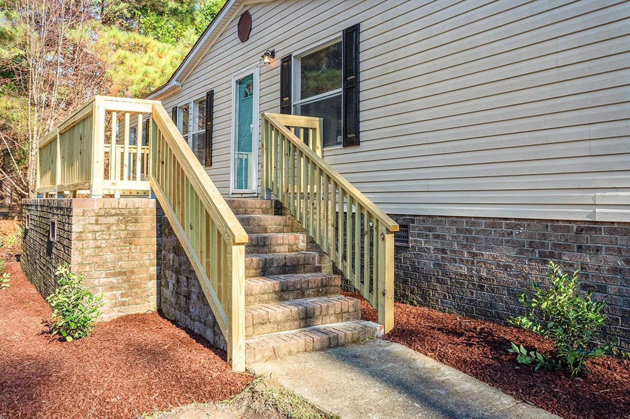 8401 South Creek Road Willow Spring, NC 27592 - Photo 18 of 24 a view of house with wooden stairs and a large tree