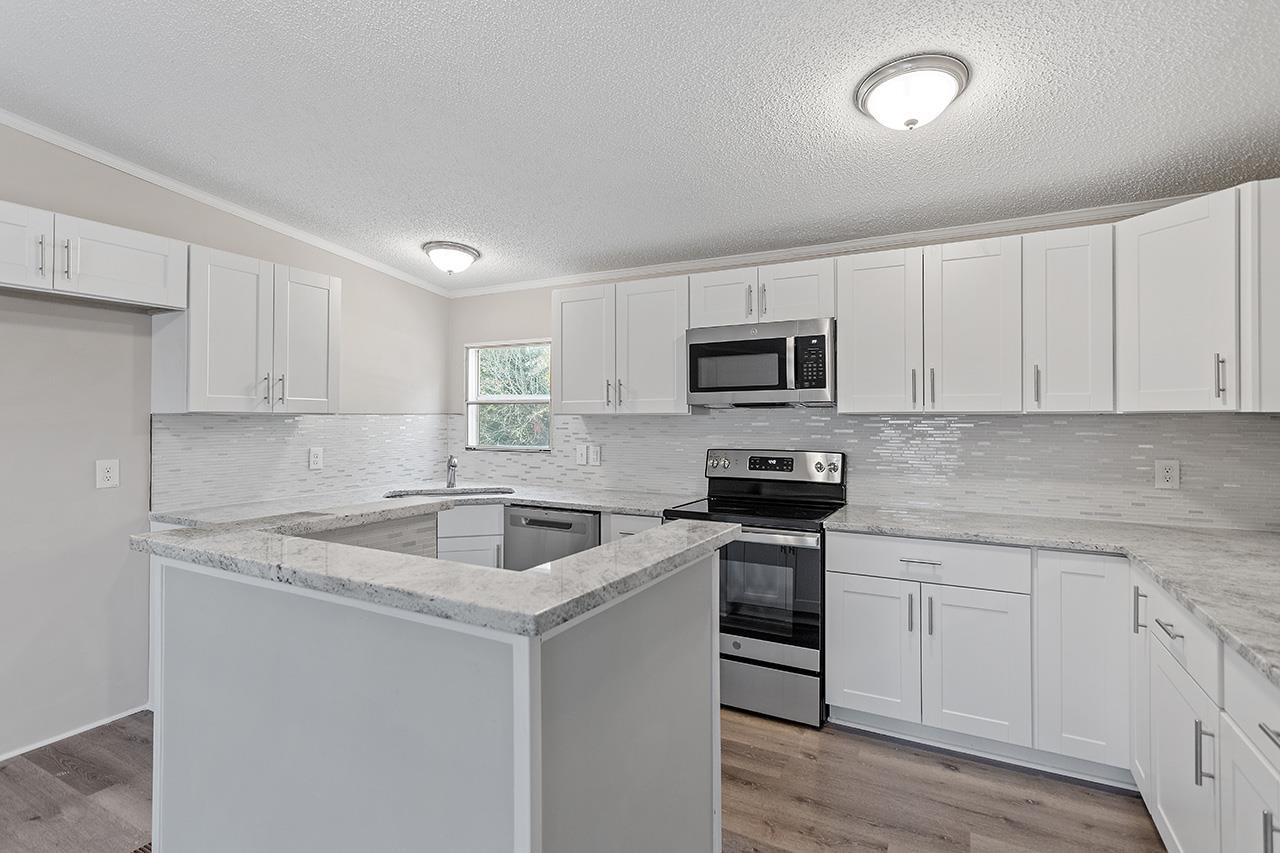 8401 South Creek Road Willow Spring, NC 27592 - Photo 3 of 24 a kitchen with sink a microwave and cabinets
