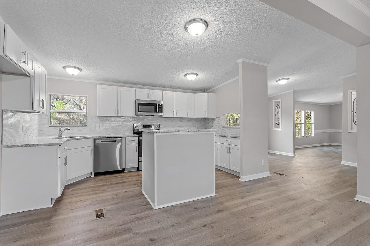 8401 South Creek Road Willow Spring, NC 27592 - Photo 10 of 24 a kitchen with a refrigerator and a stove top oven