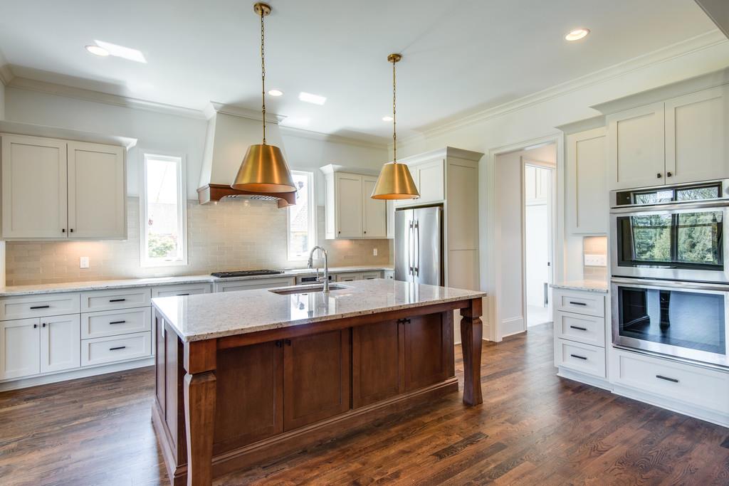 5622 Valley View Road Brentwood, TN 37027 - Photo 10 of 28 a kitchen with kitchen island granite countertop a stove a sink and a wooden floors