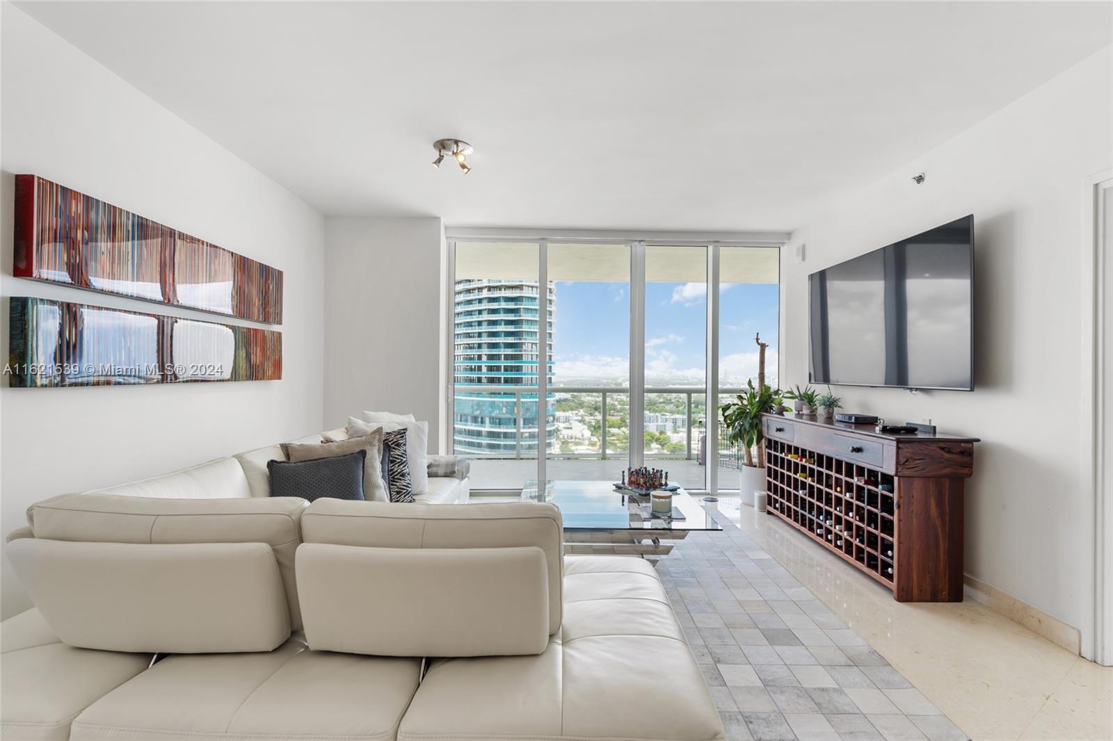 450 Alton Road, Unit 3106 Miami Beach, FL 33139 - Photo 13 of 40 a living room with furniture a flat screen tv and a large window