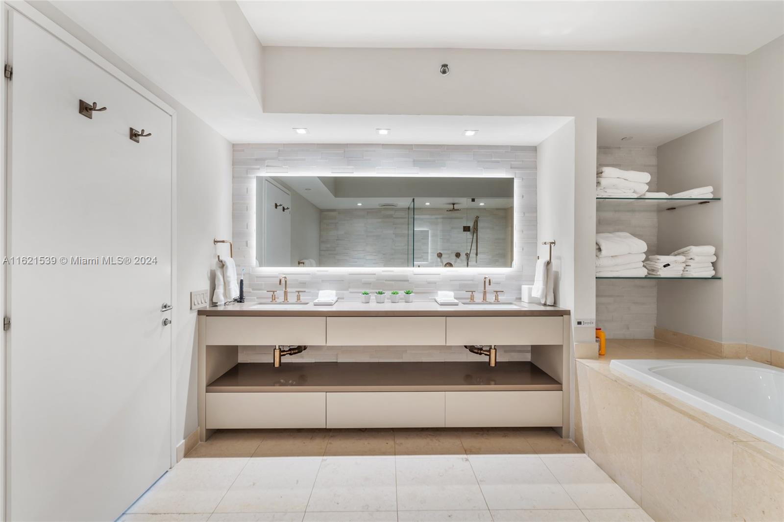 450 Alton Road, Unit 3106 Miami Beach, FL 33139 - Photo 26 of 40 a large en suite bathroom with a large tub and mirror