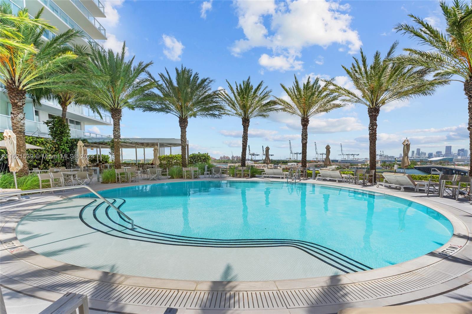 450 Alton Road, Unit 3106 Miami Beach, FL 33139 - Photo 34 of 40 a view of a swimming pool with a lounge chair and palm trees