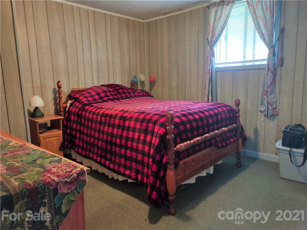 1731 Chambers Mountain Road Clyde, NC 28721 - Photo 12 of 37 a bed sitting in a bedroom next to a window