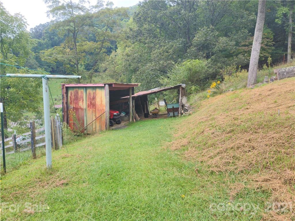 1731 Chambers Mountain Road Clyde, NC 28721 - Photo 31 of 37 a view of a backyard with wooden fence and a bench