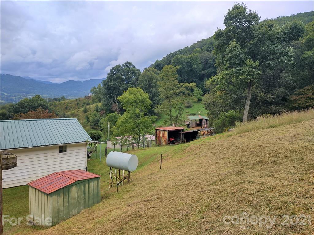 1731 Chambers Mountain Road Clyde, NC 28721 - Photo 33 of 37 a view of a patio with table and chairs potted plants with wooden floor and fence