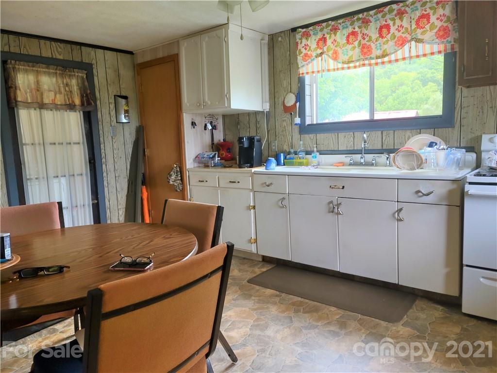 1731 Chambers Mountain Road Clyde, NC 28721 - Photo 7 of 37 a kitchen with a stove a sink and a refrigerator