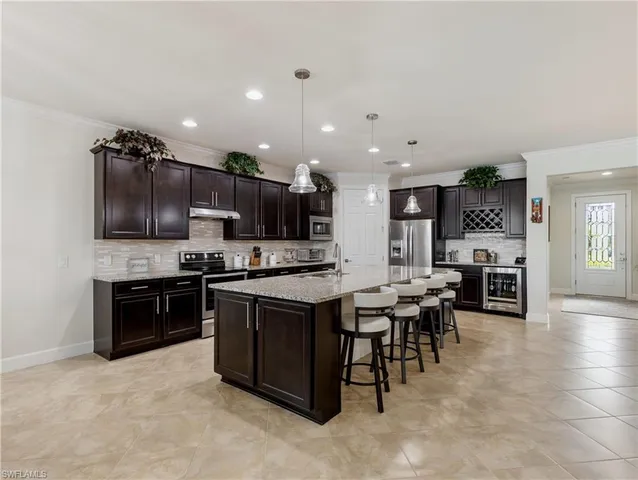 a kitchen with stainless steel appliances kitchen island granite countertop a stove top oven a sink dishwasher a dining table and chairs