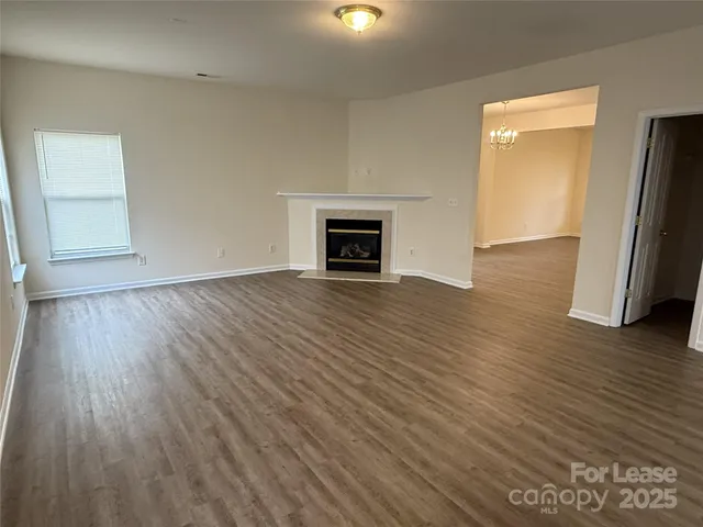 an empty room with wooden floor and a fireplace
