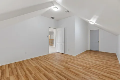 a view of an empty room with a window and kitchen view