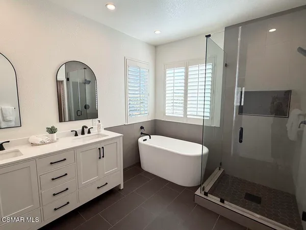 a bathroom with a double vanity sink toilet mirror and bathtub
