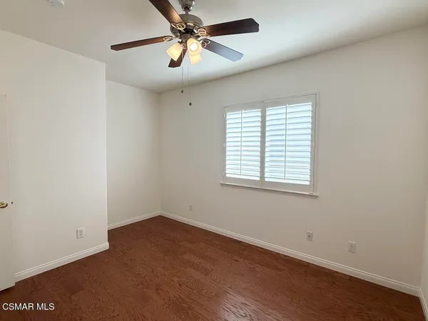 an empty room with a window and a fan