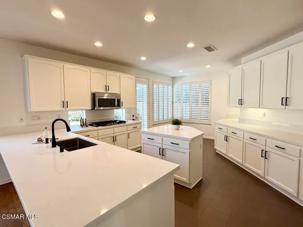 a kitchen with sink a stove and cabinets