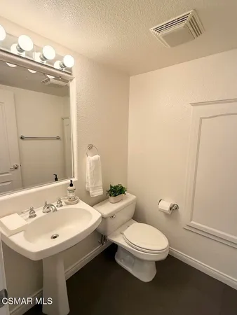a bathroom with a toilet a sink and a mirror