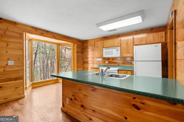 a view of a yard with trees that has wooden fence