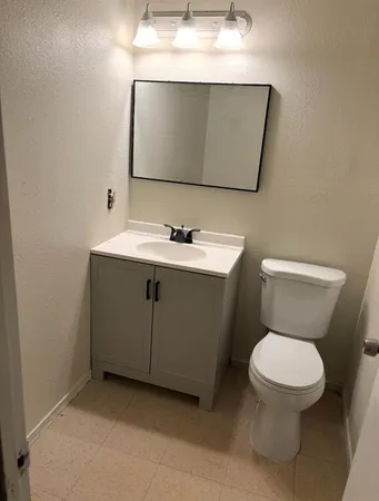 a bathroom with a toilet a sink and mirror