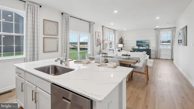 a kitchen with stainless steel appliances granite countertop a stove a sink a refrigerator a microwave and white cabinets