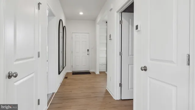 a view of a hallway with wooden floor and closet area