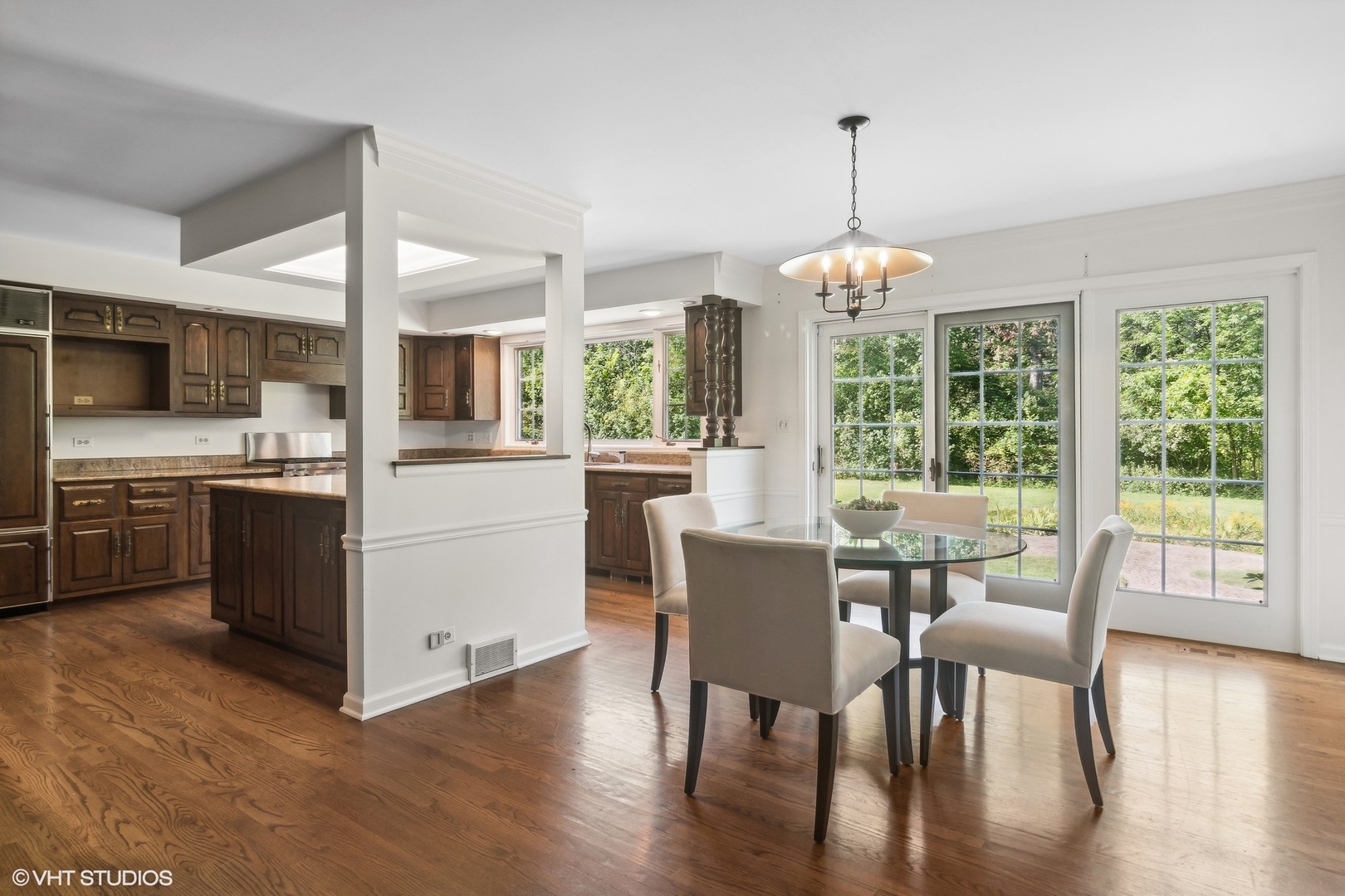 508 Forest Cove Road Lake Bluff, IL 60044 - Photo 14 of 38 a dining room with wooden floor a chandelier a wooden table and chairs
