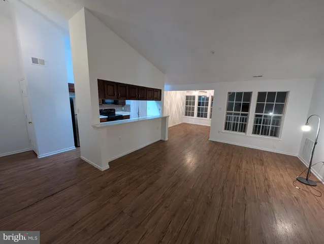 a view of a kitchen with wooden floor and electronic appliances