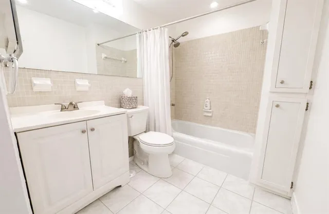 a bathroom with a double vanity sink toilet and shower