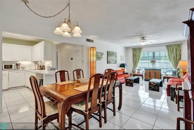 a dining room filled chandelier and wooden floor