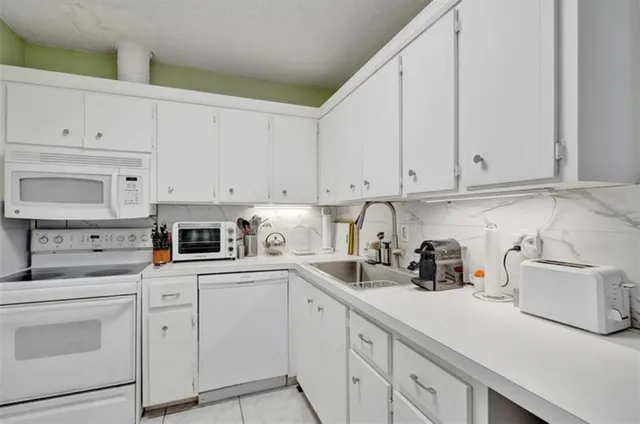a kitchen with cabinets appliances a sink and a counter