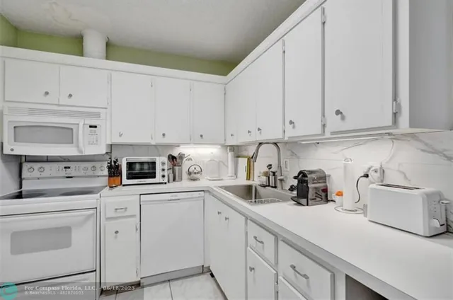 a kitchen with cabinets appliances a sink and a counter space