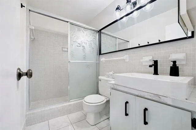a bathroom with a shower a toilet and a sink