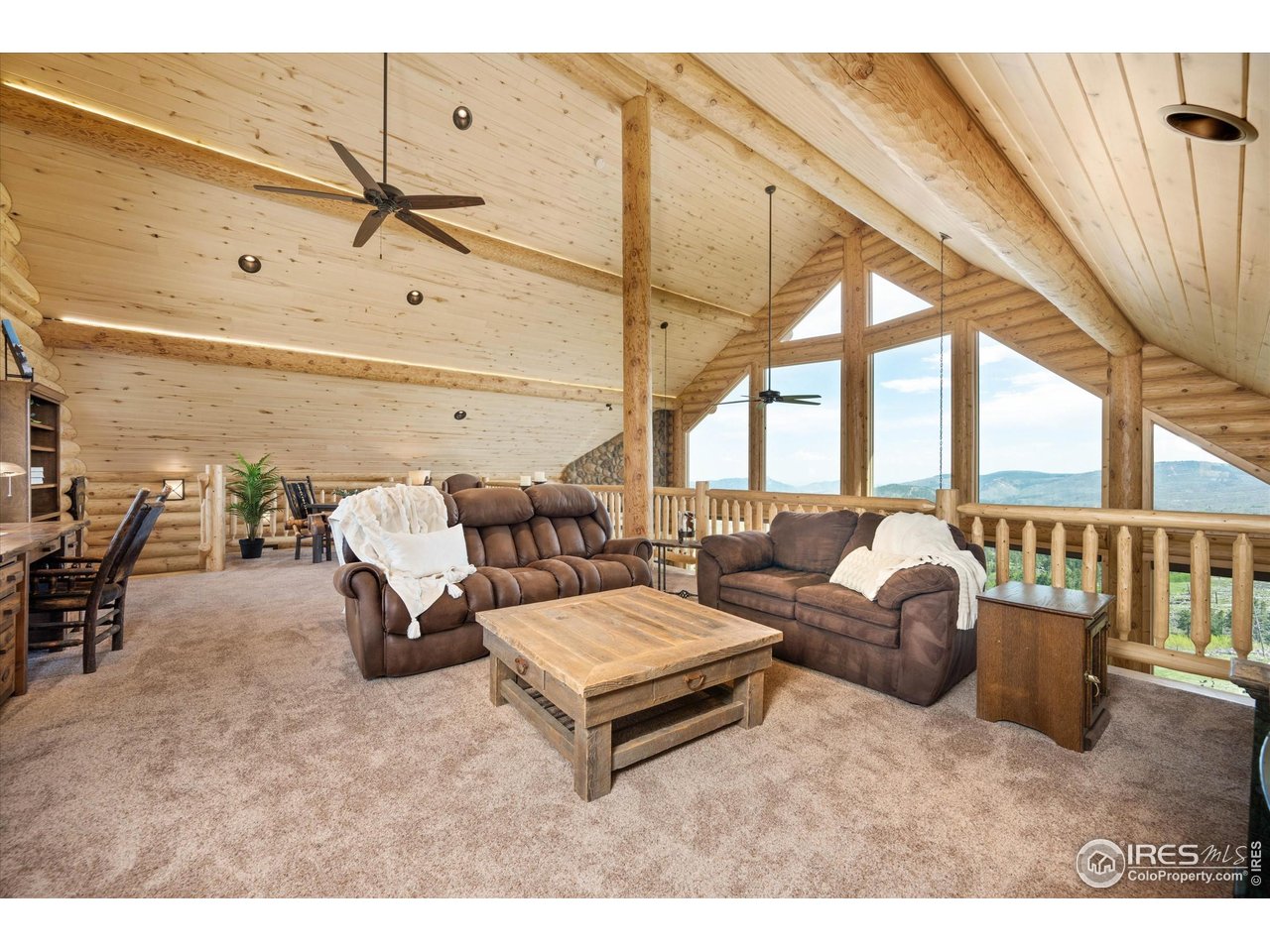 4119 Davis Ranch Road Bellvue, CO 80512 - Photo 23 of 40 a living room with furniture and a floor to ceiling window
