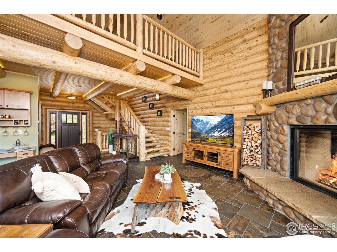 4119 Davis Ranch Road Bellvue, CO 80512 - Photo 9 of 40 a living room with furniture a flat screen tv and a fireplace