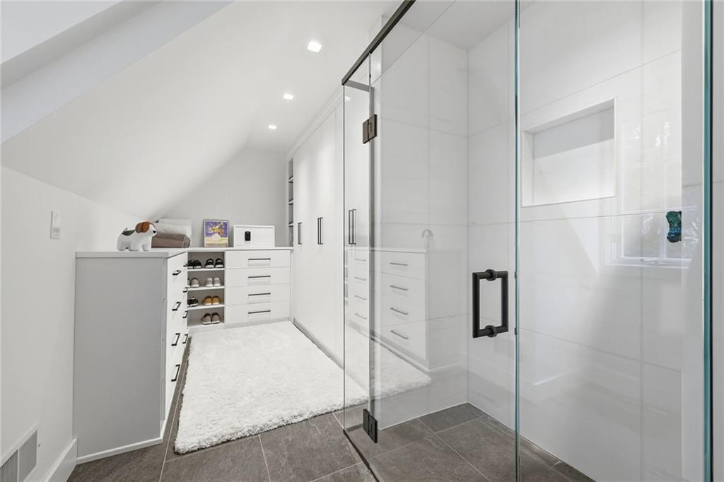 810 Persimmon Road Sewickley, PA 15143 - Photo 27 of 49 The primary bath's custom walk-in closet features built-in cabinetry, open shoe shelving, and a vaulted ceiling following the roofline.